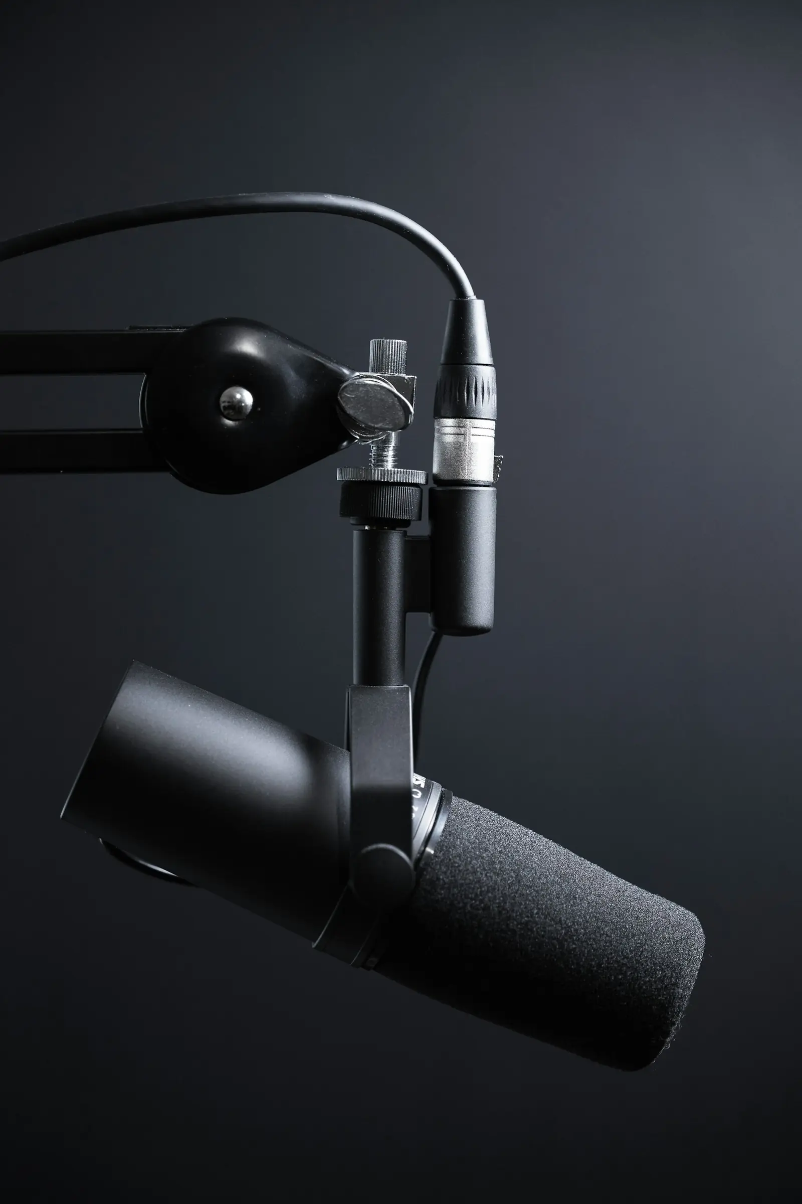 Studio microphone on a boom arm under low key lighting
