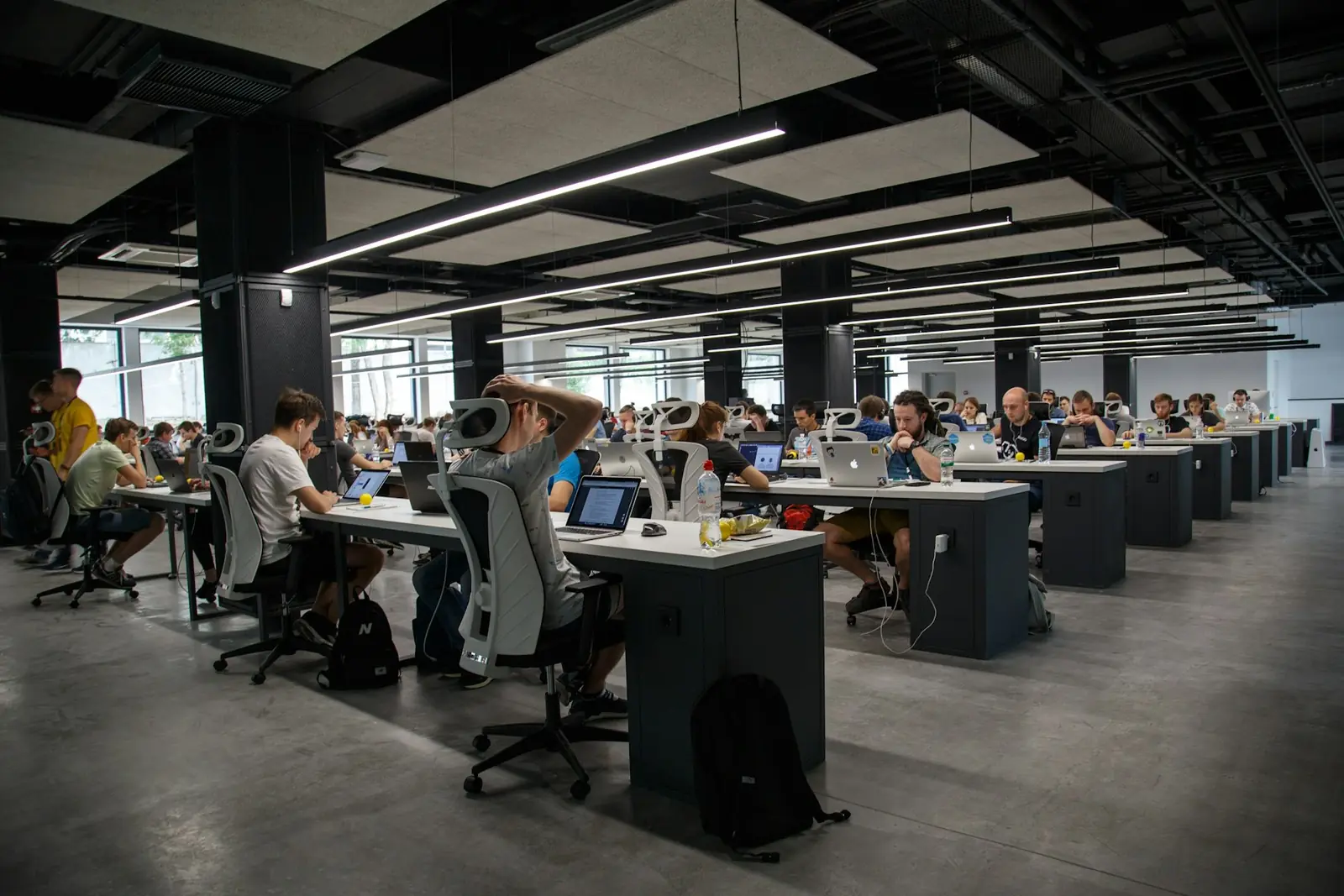 Open-plan technology workplace with teams at shared desks