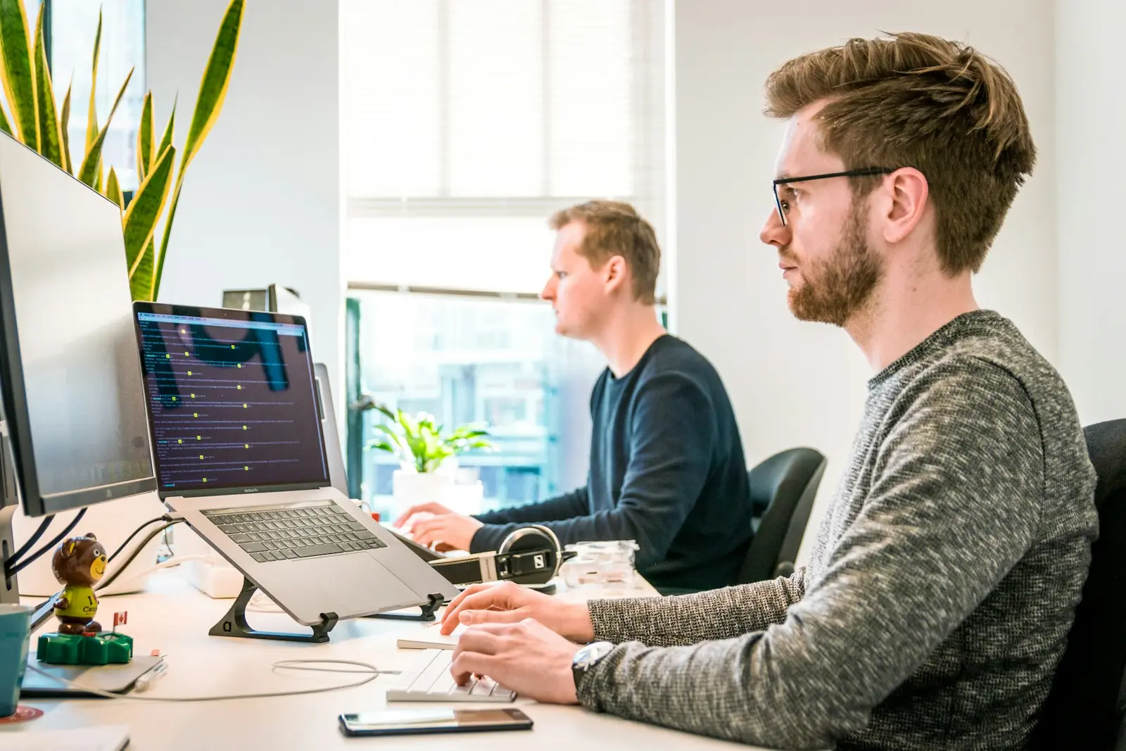 Product team working across application dashboards at adjacent desks